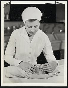 Necklace Used To Prevent Baby Mixups. New York – One of the modern devices now used in hospitals to prevent mixups of new born babies is a string of beads which are placed around the child’s neck at birth. The beads are lettered and spell out the name of the baby’s mother. A metal seal prevents removal of the necklace as long as the baby remains in the hospital. This picture made in French Hospital here shows a nurse attaching such a necklace to a new arrival.