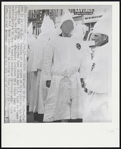 Bombing Defendant in Klan Garb--The man in Ku Klux Klan regalia at the right of this picture has been identified by city detectives Jack Shows and T.J. Ward as James D. York, one of the defendants indicted by a Grand Jury for participation in recent racial bombings in Montgomery. This picture was taken last Nov. 24 during a Klan rally in Montgomery. York, a road scraper operator for the City of Montgomery, was