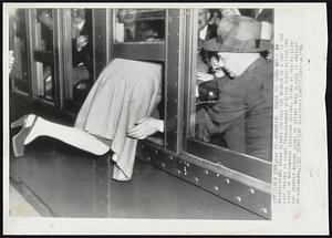 Boarding Train the Hard Way -- An unidentified woman climbs through the window of a one of the last trains to leave Pennsylvania Station today before the start of nationwide railroad strike. Doors of trains leaving shortly before start of strike were closed to prevent overcrowding.