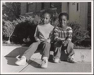 Two children sitting outside