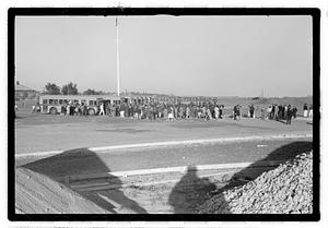 A crowd of people gathered by buses