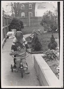 Boy and girl playing on a tricycle