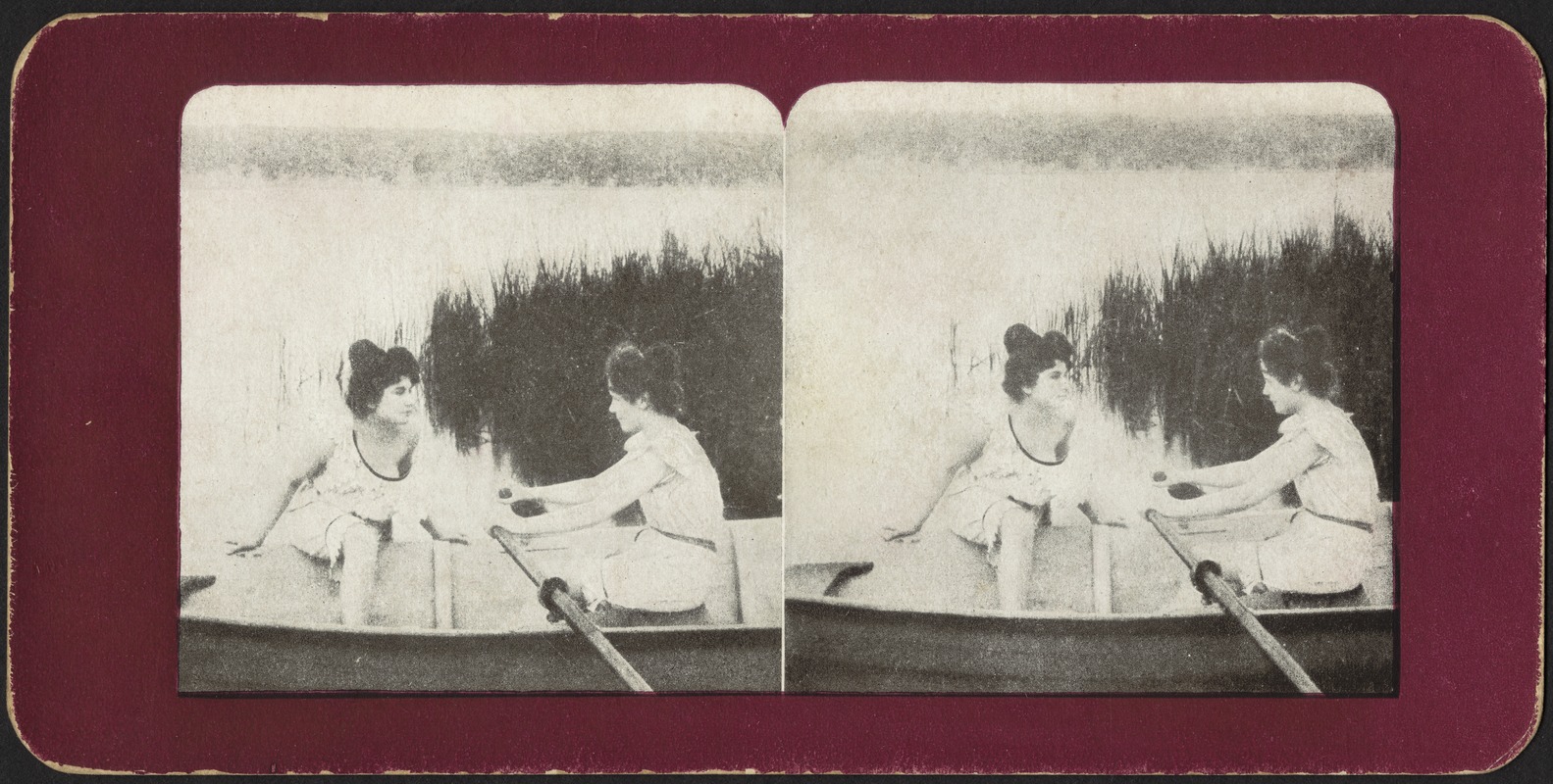 Two women rowing from shore