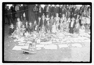 A group of girls behind a collection of items