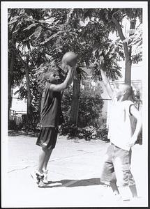 Two young men playing basketball