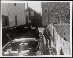 Young person washing car in an alley