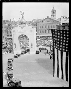 Parade of cars pass through arch in Dock Square, during Boston's Tercentenary