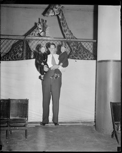Circus days: Tall man holding two girls in front of giraffes