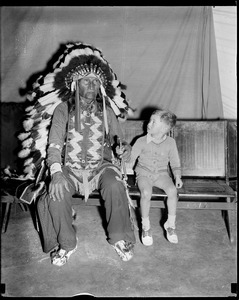 Boy holds hands with Indian at circus