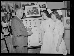 Man shows dental devices to two women in uniform
