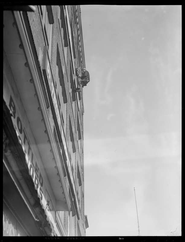 Man painting sign on building