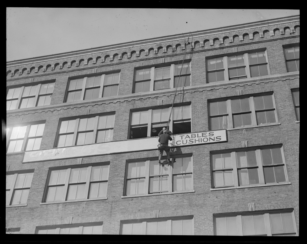 Man painting sign on building