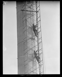 Men climbing smokestack