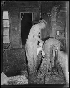 Man at grinding wheel(?)