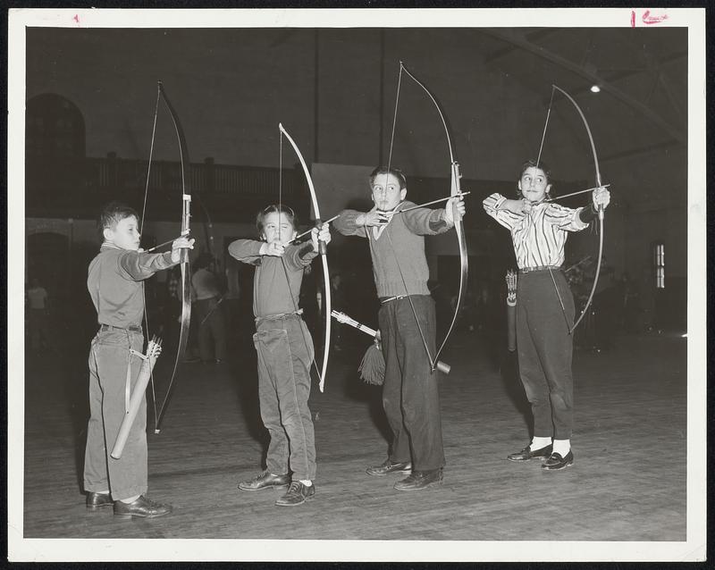 Budding William Tells sharpen up their shooting skills at West Newton Armory in program for junior members of Newton Archers. Left to right are Steven Linell, Mary Beth Oxnam, Ed Orenberg and Marjorie Fox.