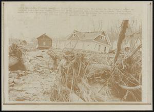Flash Flood Damage -- This was the scene in Lee, Mass., after an earthen dam gave way Sunday damaging several homes and killing one person. The damaged homes in the background and the uprooted trees give testimony to the force of the water.