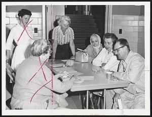 Evacuees Register at Dennisport Elementary School. From left: Mrs. Caroll White, registrar; Mrs. M. B. Turgeon; Mrs. Andre Carmel of Montreal, and her husband, Andre.