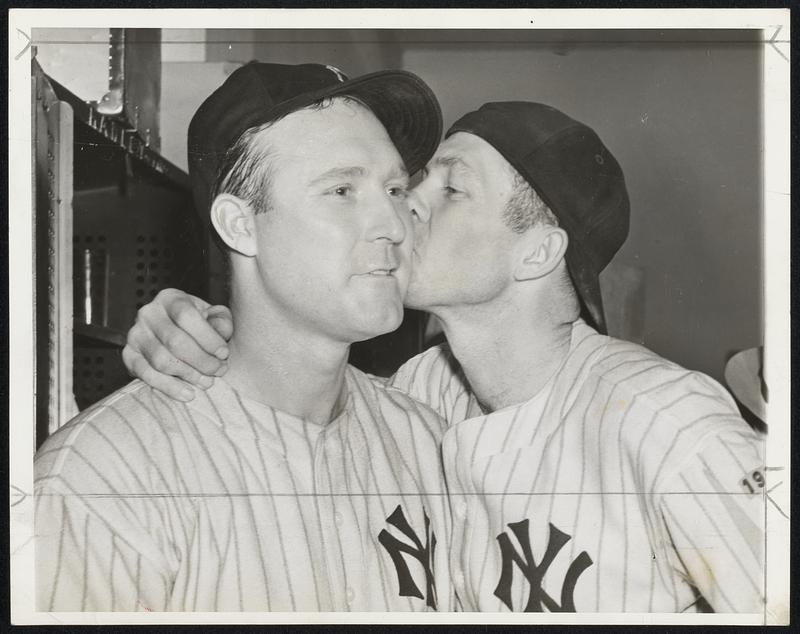Definitely proving those hard-hearted New York Yankees can be as human as the next fellow, Catcher Bill Dickey plants a real home-run smack on the cheek of his battery mate, Charlie Ruffing, during the celebration which broke loose in the dressing room after the series triumph. Bill caught all four games while Charlie hurled two of the four victories.