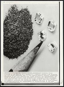 'Grown' Diamonds, Graphite-ly Speaking--These diamonds of gem quality were created in a chemical nursery from graphite, the soft black substance used in lead pencils, General Electric scientists announced in New York Thursday. The larger crystals are approximately one carat in weight. Although these diamonds have undergone slight polishing, they have not been cut and retain the shape in which they were "grown" in a special apparatus for subjecting graphite (the pile of black powder) to extreme pressures and temperatures.