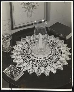 Lace and Linen make this doily unusually dainty and attractive. The center is of fine linen and a series of crocheted picots and shells form a lacy, open pattern that ends with a pointed border. For free directions on how to make this doily, send a stamped, self addressed envelope to Gloria Gould at The Boston Herald.