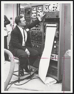 Magnet Reports its findings during a test through a cabinet of electronic equipment that makes a continuous graph shown issuing from the machine as it is operated by Frank Galeener of National Magnet Laboratory.