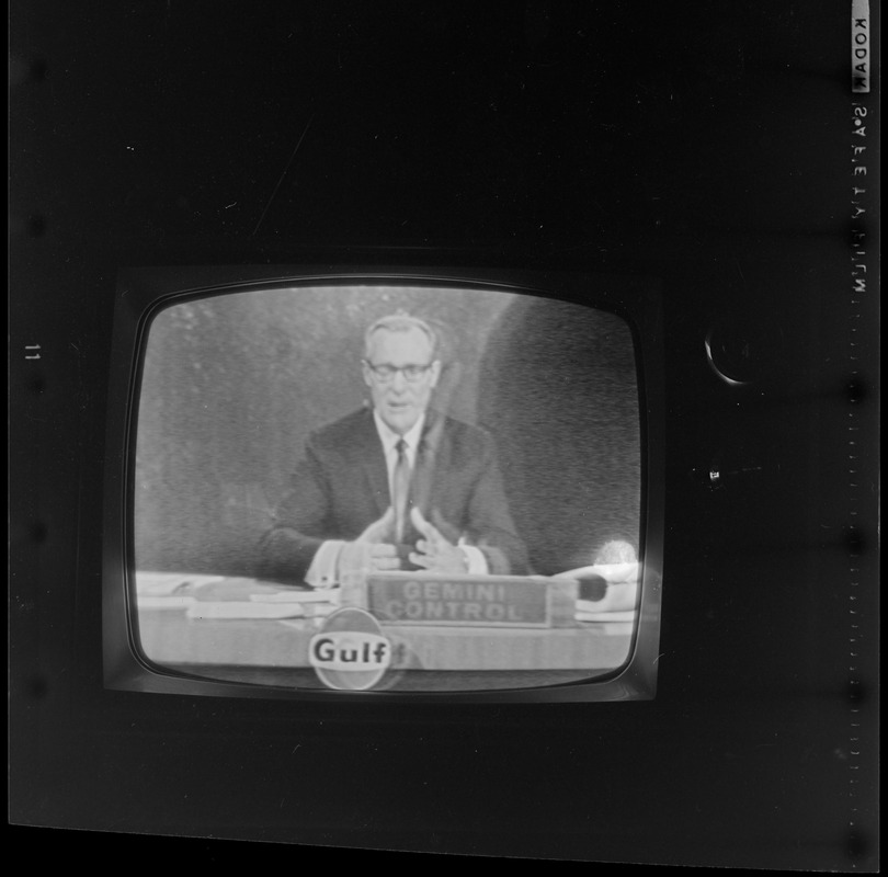 Newscaster seen on television reporting from Gemini Control