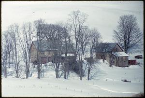 View of houses and trees on snow-covered land