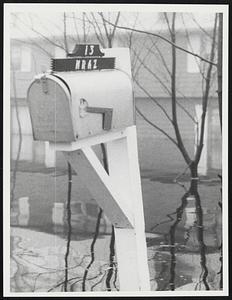Mailbox with sign, "13 Kraz" in foreground, flooding in background