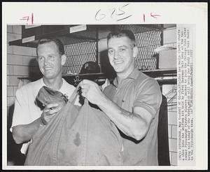 Pittsburgh – Away We Go – Outfielder Lee Walls (left) stuffs a shoe into the uniform kit held by First Baseman Dale Long as the two former Pittsburgh Pirates players packed to join the Chicago Cubs after being told today of the trade which will bring Dee Fondy and Gene Baker to the Pittsburgh team.