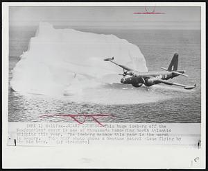 Giant Iceberg--This huge iceberg off the Newfoundland coast is one of thousands hampering North Atlantic shipping this year. The iceberg menace this year is the worst in memory. This RCAF photo shows a Neptune patrol plane flying by the big berg.