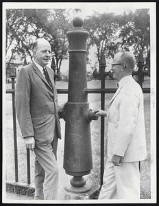 A Revolutionary War fort lies behind this ornamental fence in the Cambridgeport section of Cambridge. At the left is Barrett Williams, secretary of the Bostonian Society and author of this article. At right is Prof. Douglas P. Adams of MIT.