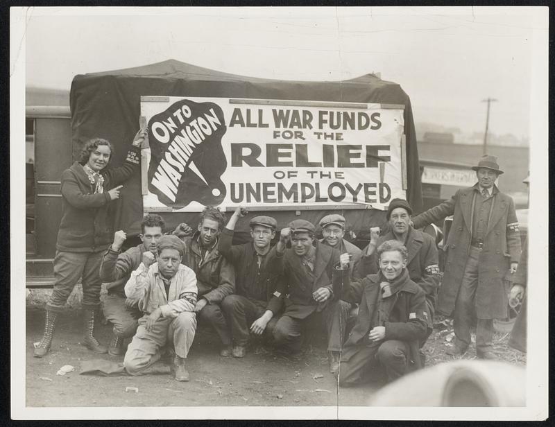 "Hunger Marchers" near Capital. Miss Helmi Huttunen, of Seattle, Wash., standing by the truck pointing to "On To Washington" sign as the self-styled "Hunger Marchers", numbering 1300, comprising the "Western Division" stopped at Uniontown., Pa., enroute to the capital. This group was later met by a citizen army armed with gas and machine guns and forced to continue hurriedly on their way instead of "occupying" the city for the night as they originally planned to do.