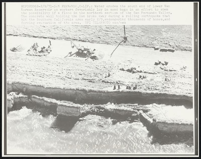 Water erodes the south end of Lower Van Norman Reservoir as workers feverishly lay in sand bags in an effort to stem the possibility if a flood in the northern section of the San Fernando Valley. The concrete wall holding the Dam broke away during a rolling earthquake that hit the Southern California area 2/9, endangering thousands of homes, and forcing evacuation of the area.