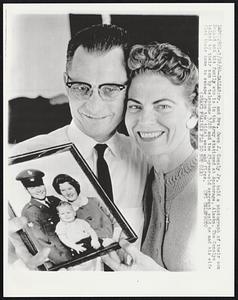 Mr. and Mrs. Owen J. Conoly Jr. hold a photograph of their son Donald and his family who is in the Army stationed at Anchorage. The Conolys talked to their son by telephone 3/28 and the 23-year-old sergeant said he and his wife fled their home to escape from the tidal waves and fires.