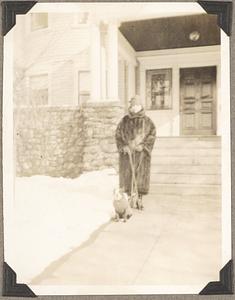 Natalie Koussevitzky in a fur coat holds the leash of a Boston terrier