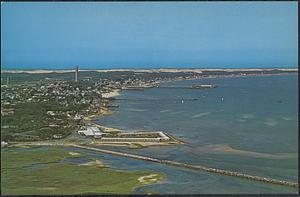 Air view of Provincetown Harbor showing the famous Pilgrim Monument, Town Pier, and sand dunes, Provincetown, Cape Cod, Mass.