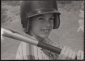 Boy smiling with baseball helmet and bat