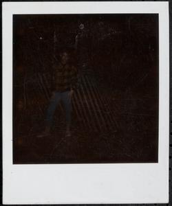 Young person standing in front of a fence