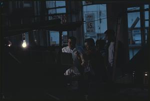 People in indoor space with price signs on windows