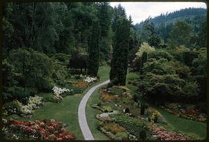 Flower garden with path set among forest and hills, British Columbia