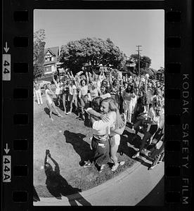 Two women hug while crowd cheers