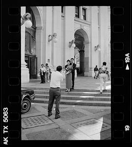 Formally dressed couple being photographed, possibly after a civil wedding