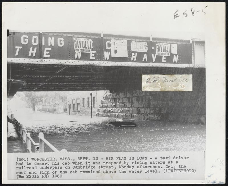 His Flag is Down- A taxi driver had to desert his cab when it was trapped by rising waters at a railroad underpass on Cambridge street, Monday afternoon. Only the roof and sigh of the cab remained above the water level.