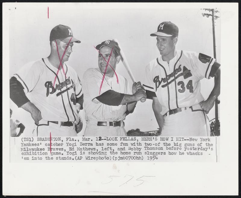 Bradenton, Fla. – Look Fellas, Here’s How I Hit – New York Yankees’ catcher Yogi Berra has some fun with two of the big guns of Milwaukee Braves, Ed Mathews, left, and Bobby Thomson before yesterday’s exhibition game. Yogi is showing the home run sluggers how he whacks ‘em in the stands.