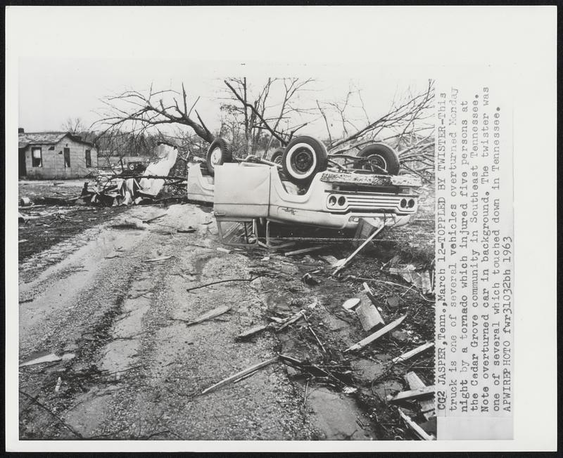 Toppled by Twister-This truck is one of several vehicles overturned Monday night by a tornado which injured five persons at the Cedar Grove community in Southeast Tennessee. Note overturned car in background. The twister was one of several which touched down in Tennessee.