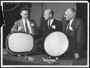 Color Television moves into the big-screen class with these samples of new 21-inch round and 22-inch rectangular color picture tubes produced by Raytheon Manufacturing Company. In center is Charles F. Adams, Jr., president of the Waltham, Mass., electronics firm. N.B. Krim, left, vice president and general manager of the Receiving & Cathode Ray Tube Operations, discusses the new development with Mr. Adams and F.E. Anderson, manager of replacement and export sales.