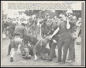 San Francisco State College Chaplain Jerry Pederson (R) protests police clubbing of student activists while he, himself, has billy club around his neck during eruption of violence on the campus 12/5. Pederson was seized along with Carlton Goodlett, Publisher of a Negro newspaper, after some 100 members of the Negro community joined a rally of about 2,000 students.