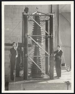 It Makes "Neutrons" -- This Strange Machine, Recently Completed at the California Institute of Technology, is the First to Manufacture "Neutrons" Constituents of the Atom. It Has Actually Converted One Element Into Another. Dr. Richard Crane, Left, and Dr. Andrew Soltan, Right, Constructed the Machine Under the Direction of Dr. Charles Lauritsen.