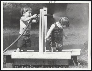 The Only Way to treat a lady on a hot Sunday is the way two-year-old David Cubie treated one-year-old Betsy MacDonald in her own pool on Copley St., Quincy.