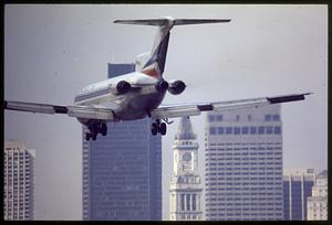 Arriving jetliner at Logan Airport and downtown skyline, East Boston